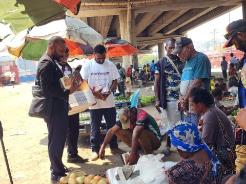 Praying with the local at Erima market
