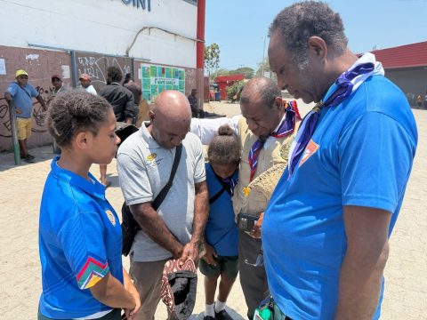 KPEC Pathfinders and leaders praying with a member of the public at Boroko.